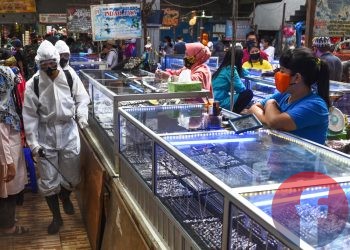 Petugas melakukan penyemprotan disinfektan di los yang ada di Pasar KM 5. (matakamera/fornews.co/mushaful imam)