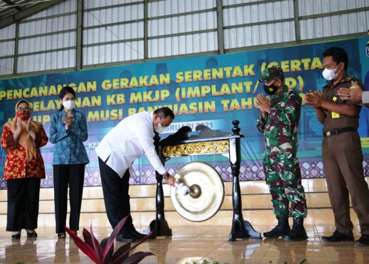 Bupati Muba Dodi Reza Alex memukul gong menandai dimulainya Gertak Pelayanan KB MKJP Tahun 2021 di Gedung Sorga Desa, Desa Lumpatan II, Kecamatan Sekayu, Rabu (3/2/2021). (fornews.co/humas pemkab muba)