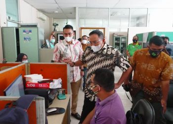 Bupati Muba Dodi Reza Alex memperhatikan pekerjaan seorang pegawai saat melakukan Sidak di Dispopar Muba, Jumat (5/2/2021). (fornews.co/humas pemkab muba)