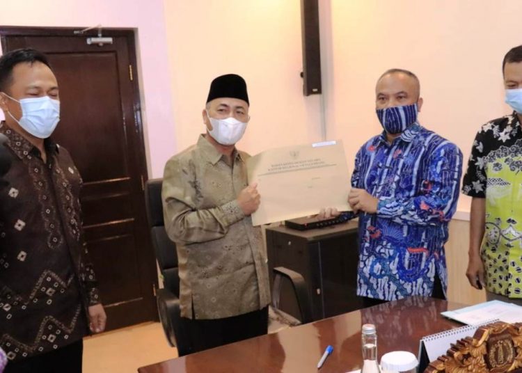 Sekda Muba Apriyadi menerima berkas administrasi kepegawaian Pemkab Muba yang diserahkan Kepala Kantor Regional VII Badan Kepegawaian Negara (BKN) Palembang, Margi Prayitno, di Ruang Rapat Sekda, Jumat (5/2/2021). (fornews.co/humas pemkab muba)