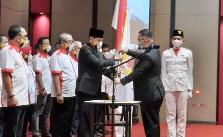 Ketua Umum KONI Sumsel Hendri Zainuddin menyerahkan pataka KONI OKU kepada Supriadi Jazid yang dilantik sebagai Ketua KONI OKU periode 2020-2024 di ballroom Hotel The Zuri Batuaraja, Sabtu (6/2/2021). (fornews.co/humas koni sumsel)