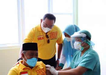 Bupati Muba Dodi Reza Alex memberi semangat seorang tenaga kesehatan lanjut usia yang mendapatkan vaksinasi Covid-19 perdana, Kamis (11/2/2021). (fornews.co/humas pemkab muba)