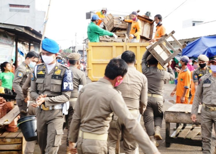 Petugas Sat Pol PP Kabupaten Muba mengangkut meja pedagang yang nekat berjualan di eks Pasar Pagi Talang Jawe pada penertiban yang dilakukan Rabu (24/2/2021). (fornews.co/humas pemkab muba)