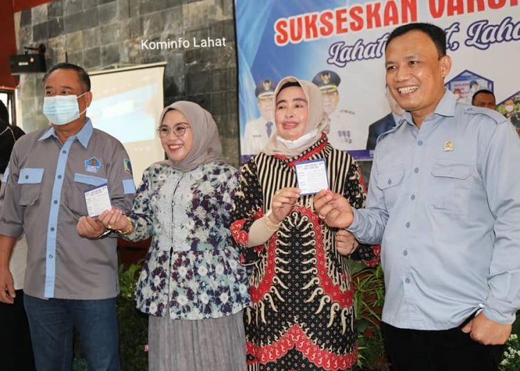 Bupati Lahat Cik Ujang dan Istri, menunjukkan kartu peserta vaksinasi tahap kedua di Gedung Pertemuan Pemkab Lahat, Minggu (7/3/2021). (fornews.co/diskominfo lahat)