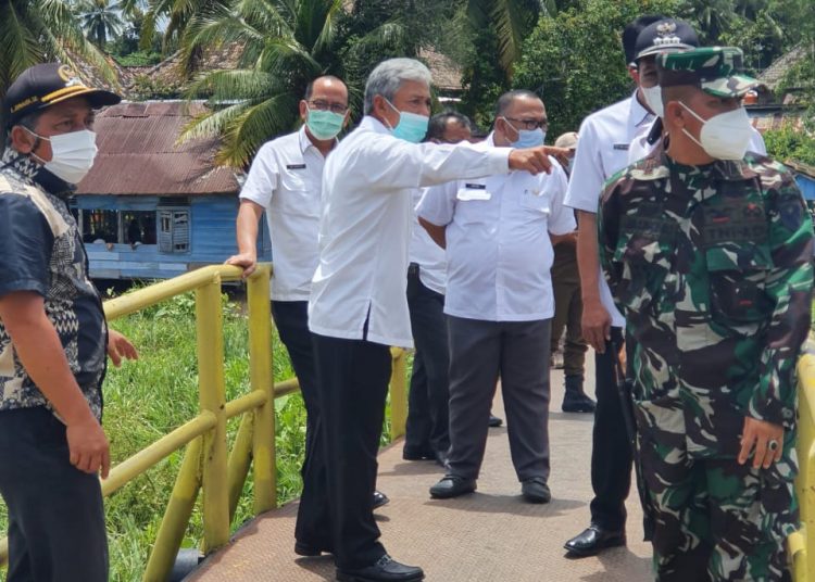 Bupati OKI, H Iskandar SE saat meninjau langsung kondisi jembatan di Desa Srigeni yang putus, Kamis (25/03). (fornews.co / IST)