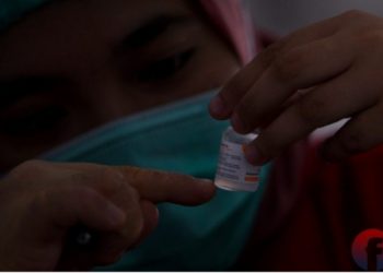 Petugas memeriksa vaksin yang akan disuntikkan. (matakamera/fornews.co/mushaful imam)