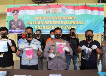 Kapolres Banyuasin AKBP Imam Tarmudi dan Kasat Narkoba Polres Banyuasin AKP Widhi Andika Darma menunjukkan barang bukti yang diamankan pada penggerebekan di Dusun Menara, Desa Lubuk Lancang, pada press release di Mapolres Banyuasin, Senin (29/3/2021). (fornews.co/humas polres banyuasin)