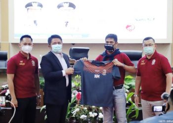 Gubernur Sumsel Herman Deru yang juga Dewan Pembina Sriwijaya FC menyerahkan jersei ke Nil Maizar yang secara resmi menjadi pelatih Sriwijaya FC musim 2021 usai penandatangan kontrak, Senin (15/3/2021). (fornews.co/humas provinsi sumsel)