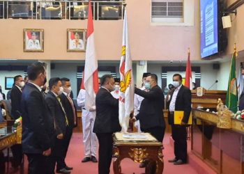 Ketua Umum KONI Sumsel Hendri Zainuddin menyerahkan pataka ke Ketua KONI Palembang Anton Nurdin pada pelantikan pengurus KONI Palembang masa bakti 2021-2025 di ruang rapat Parameswara, Pemkot Palembang, Rabu (3/3/2021). (fornews.co/humas koni sumsel)