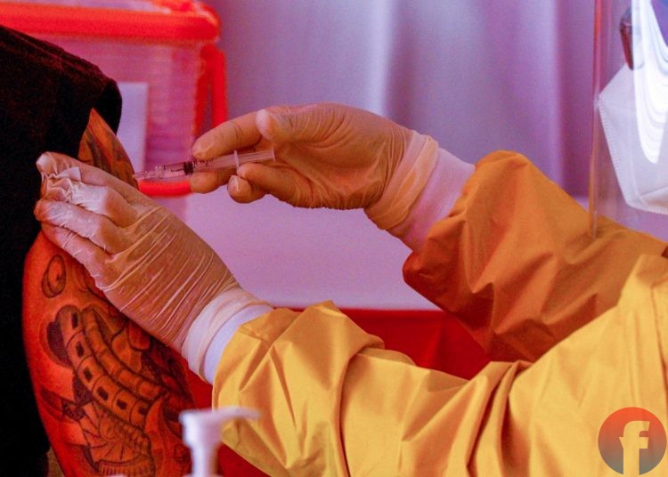 Petugas vaksinator menyuntikkan vaksin di lengan pedagang Pasar Cinde. (matakamera/fornews.co/mushaful imam)