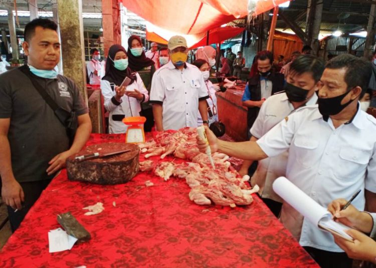 Petugas dari Tim Pemantauan Kabupaten memeriksa daging ayam yang dijual di salah satu pasar di Muba, Rabu (24/3/2021). (fornews.co/humas pemkab muba)