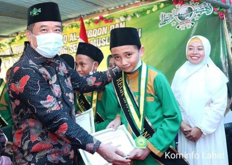 Bupati Lahat Cik Ujang menyerahkan penghargaan kepada salah seorang santri saat menghadiri pelantikan Pengurus Ranting dan Muslimat Nahdlatul Ulama Desa Ulak Mas, Kecamatan Lahat, Sabtu (3/4/2021). (fornews.co/kominfo lahat)