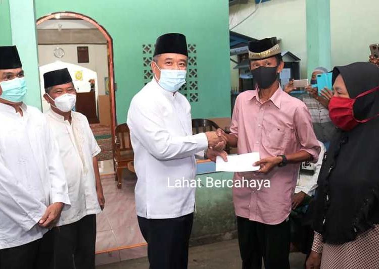 Bupati Lahat Cik Ujang menyerahkan bantuan dari para guru di Kabupaten Lahat kepada korban kebakaran di Kelurahan Pasar Bawah, Rabu (28/4/2021). (fornews.co/kominfo lahat)