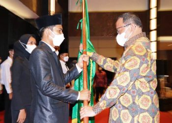 Bupati Muba Dodi Reza Alex menyerahkan pataka IMMuba kepada Ketua Umum IMMuba periode 2021-2023 Vortuna Unmabsi pada pelantikan di Grand Atyasa Convention Center Palembang, Minggu (11/4/2021). (fornews.co/humas pemkab muba)