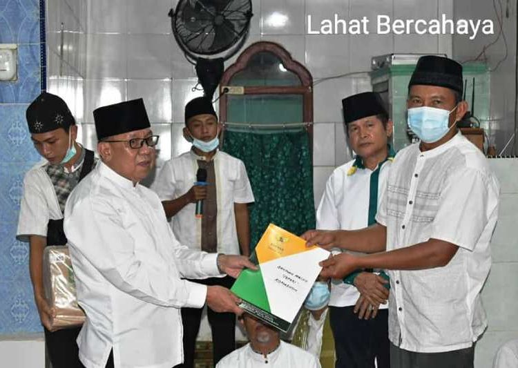 Wakil Bupati Lahat Haryanto menyerahkan bantuan Alquran kepada pengurus Masjid Al-Iklhas Desa Nanjungan, Kecamatan Kikim Selatan, Senin (19/4/2021). (fornews.co/kominfo lahat)