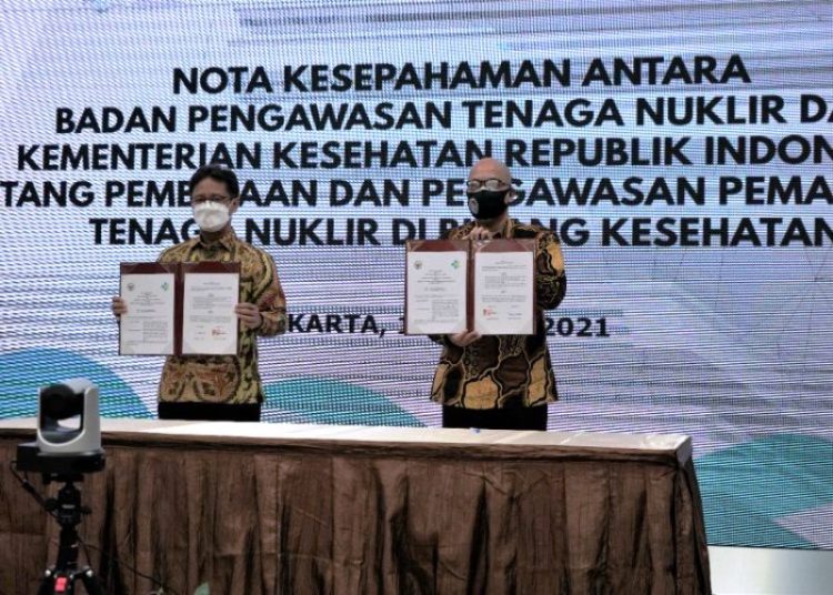 Menteri Kesehatan Budi Gunadi Sadikin dan Kepala Bapeten Prof. Jazi Eko Istiyanto menunjukkan nota kesepahaman mengenai perpanjangan kerja sama pemanfaatan tenaga nuklir di bidang kesehatan yang ditandatangani di gedung Kementerian Kesehatan RI, Jumat (16/4/2021). (fornews.co/bkpm kemenkes) 