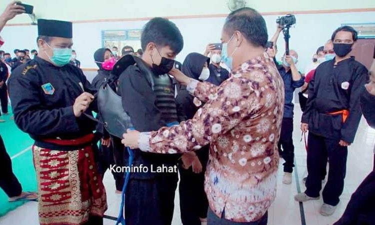 Bupati Lahat Cik Ujang memasangkan body protector kepada peserta Kejuaraan Pencak Silat Bupati Lahat Cup di Aula SMK Negeri 1 Lahat, Minggu (28/3/2021). (fornews.co/kominfo lahat)