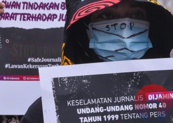 Seorang peserta aksi membawa poster kampanye keselamatan jurnalis. (matakamera/fornews.co/mushaful imam)