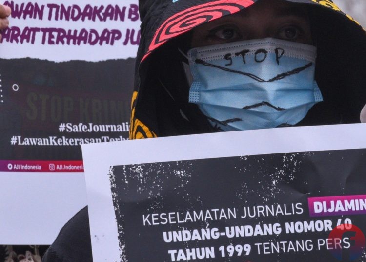 Seorang peserta aksi membawa poster kampanye keselamatan jurnalis. (matakamera/fornews.co/mushaful imam)