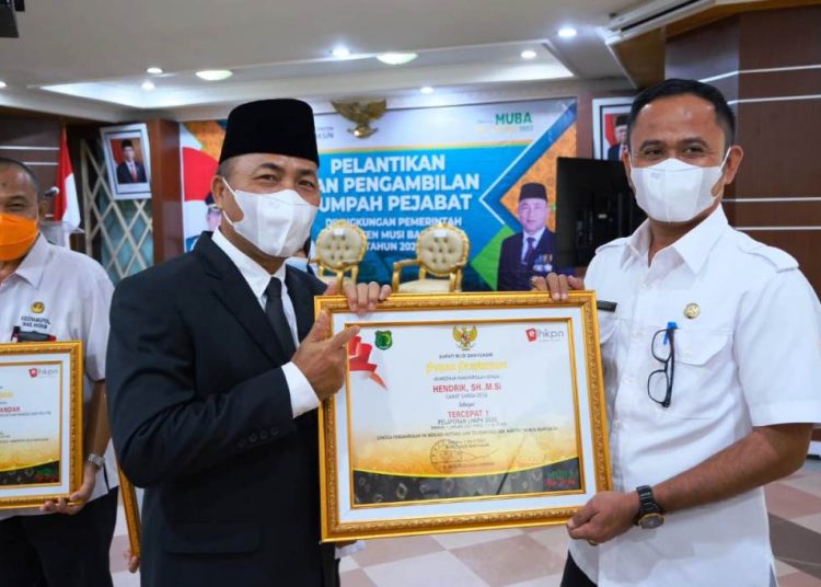 Sekda Muba Apriyadi menyerahkan penghargaan Bupati Muba kepada Camat Sanga Desa Hendrik karena menjadi ASN tercepat sampaikan LHKPN 2020 di auditorium Pemkab Muba, Senin (5/4/2021). (fornews.co/humas pemkab muba)