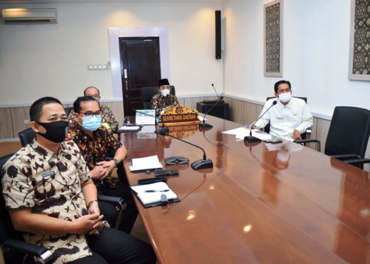Sekda Muba Apriyadi didampingi pimpinan OPD Muba mengikuti Rapat Standar Pelayanan Publik Kabupaten/Kota se-Sumatra Selatan secara virtual, Jumat (23/4/2021). (fornews.co/humas pemkab muba)