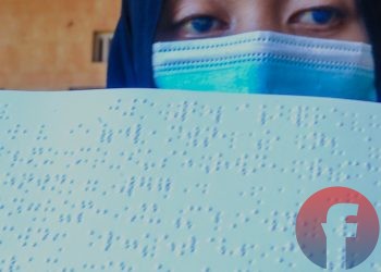 Meisari, seorang penyandang tunanetra, yang matanya kebiru- biruan menunjukkan Alquran braille yang ia baca. (matakamera/fornews.co/mushaful imam)