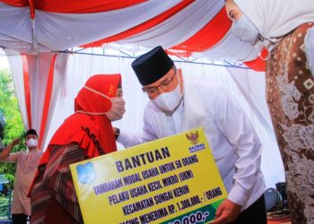 Bupati Muba Dodi Reza Alex menyerahkan bantuan kepada pelaku UMKM saat menghadiri Safari Ramadan 1442H Pemkab Muba di Desa Rantau Sialang, Kecamatan Sungai Keruh, Sabtu (24/4/2021). (fornews.co/humas pemkab muba)