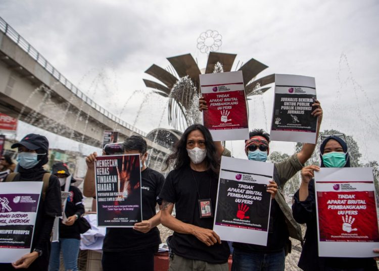 Para jurnalis mengangkat tinggi poster tuntutan dan kecaman dalam aksi di Bundaran Air Mancur Palembang, Kamis (01/03/21). (fornews/istimewa/Dok. PFI Palembang)