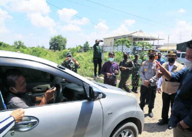 Gubernur Sumsel Herman Deru menyapa pengendara yang melintas di pos penyekatan mudik Idulfitri 1442H di wilayah Kota Palembang, Sabtu (8/5/2021). (fornews.co/humas provinsi sumsel)