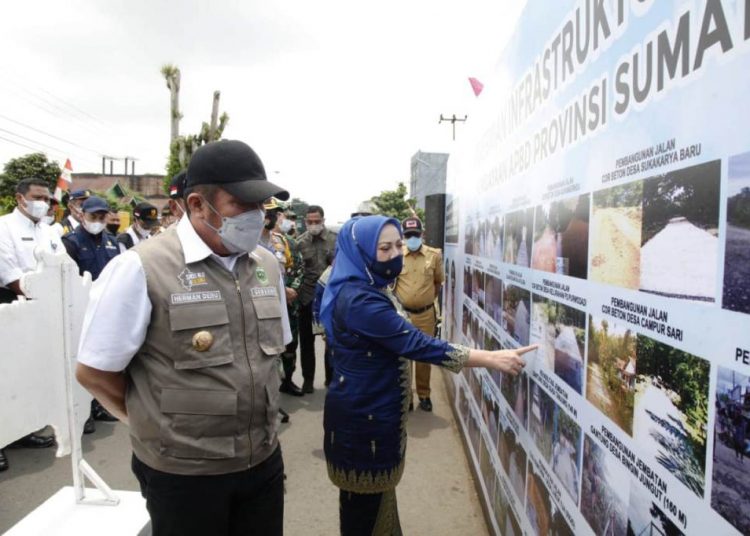Gubernur Sumsel Herman Deru menyimak Bupati Musi Rawas Ratna Machmud yang menerangkan infrastruktur yang telah selesai dibangun di Mura dengan bantuan APBD Provinsi Sumsel dan Bangubsus pada peresmian di lapangan bola Desa F Trikoyo Kecamatan Tugumulyo, Selasa (20/4/2021). (fornews.co/humas provinsi sumsel)