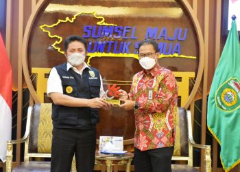 Gubernur Sumsel Herman Deru menerima cendera mata dari GM Telkom Wilayah Telekomunikasi Sumsel Mustakim Wahyudi, Kamis (6/5/2021). (fornews.co/humas provinsi sumsel)