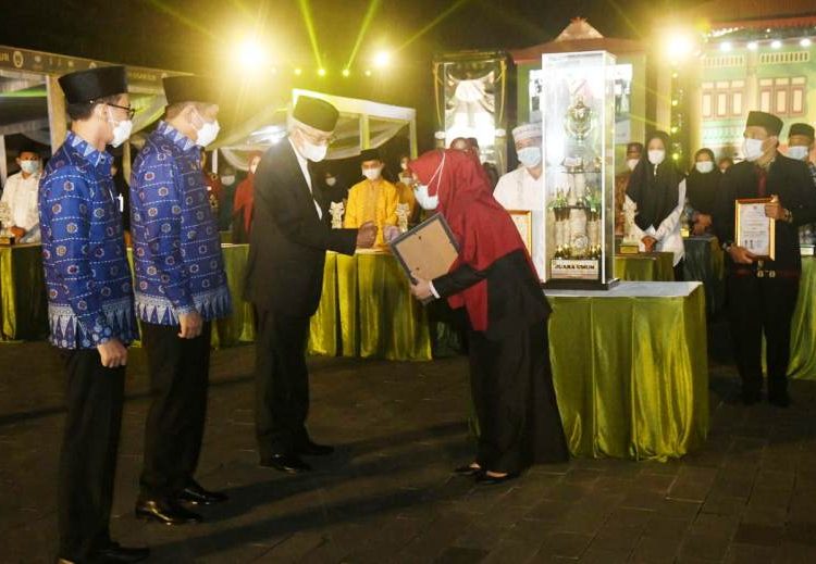 Wakil Gubernur Sumsel Mawardi Yahya menyerahkan piagam penghargaan kepada perwakilan kafilah pada penutupan STQH XXVI Tingkat Provinsi Sumsel Tahun 2021 di Lapangan Tani Merdeka Martapura, Kabupaten OKU Timur, Rabu malam (26/5/2021). (fornews.co/humas provinsi sumsel)