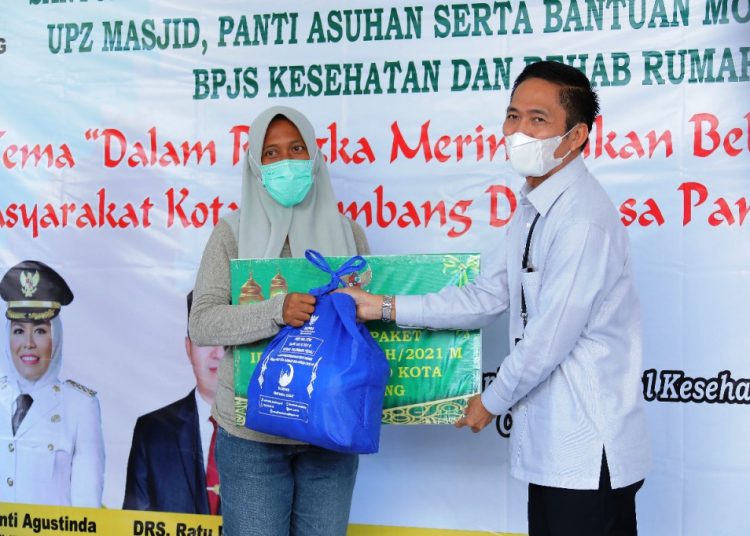 Sekda Palembang Ratu Dewa menyerahkan paket bingkisan Idulfitri 1442H kepada warga yang berhak menerima, Senin (10/5/2021). (fornews.co/bakohumas palembang)