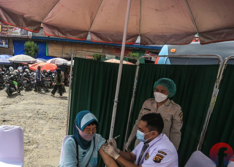 Tenaga vaksinator melakukan vaksinasi Covid-19 kepada Lansia yang merupakan pengunjung Pasar Km 5 Palembang. (matakamera/fornews.co/mushaful imam)