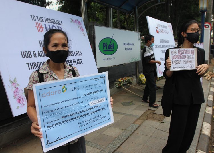 Sejumlah aktivis melakukan aksi teaterikal dan mengirimkan karangan bunga untuk sindikasi perbankan pemberi pinjaman dan ADRO, Senin (3/5). (istimewa)