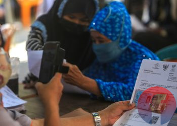 Petugas memfoto berkas dan penerima Bantuan Sosial Tunai di Kantor Pos Pusat Jalan Merdeka Palembang, Senin (26/7/2021). (fornews.co/mushaful imam)