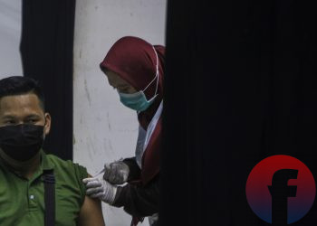 Petugas vaksinator sedang menyuntikkan vaksin Covid-19. (matakamera/fornews.co/mushaful imam)