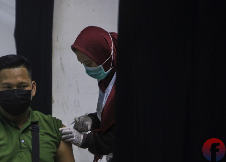 Petugas vaksinator sedang menyuntikkan vaksin Covid-19. (matakamera/fornews.co/mushaful imam)
