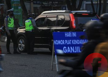 Petugas memberikan penjelasan kepada pengemudi mobil mengenai pemberlakuan genap ganjil. (matakamera/fornews.co/mushaful imam)