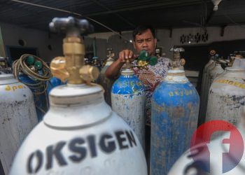 Pemilik tempat pengisian di Jalan Sultan M Mansur, Lorong Family, 35 Ilir, lagi melakukan pengecekan tekanan oksigen dalam tabung, Sabtu (17/6/2021). (fornews.co/mushaful imam)
