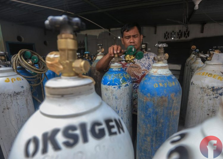 Pemilik tempat pengisian di Jalan Sultan M Mansur, Lorong Family, 35 Ilir, lagi melakukan pengecekan tekanan oksigen dalam tabung, Sabtu (17/6/2021). (fornews.co/mushaful imam)