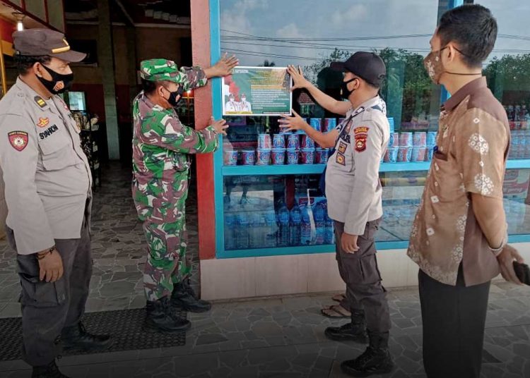 PEMASANGAN stiker himbauan di warung makan dan restoran di Kecamatan Babat Supat, Kabupaten Musi Banyuasin, selama PPKM diberlakukan. (foto fornews.co/humas pemkab muba)