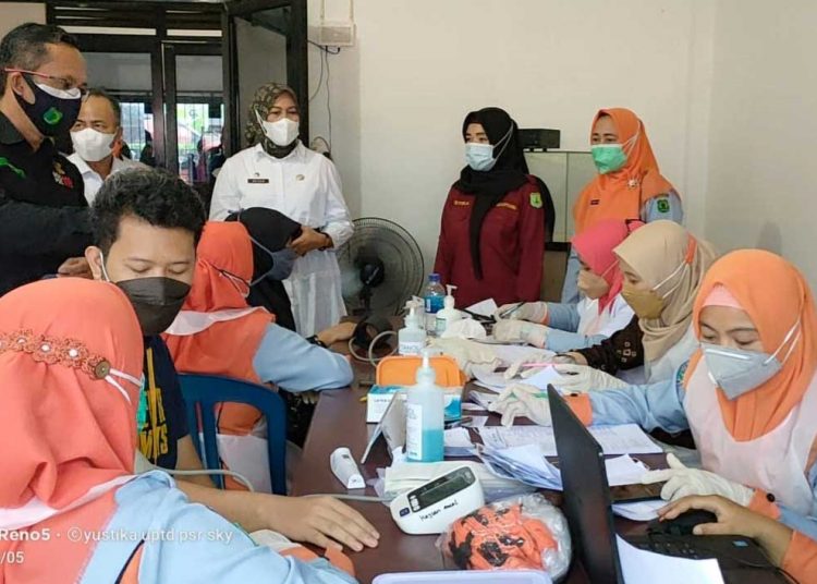 PETUGAS tenaga kesehatan sedang melakukan swab antigen terhadap salah seorang pedagang di Pasar Randik, Sekayu, Muba. (foto fornews.co/humas pemkab muba)