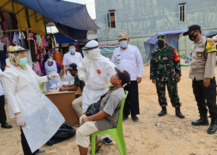 Petugas lagi melakukan swab kepada salah satu pedagang di Pasar Randik, Sekayu, Kamis (5/8/2021). (fornews.co/humas pemkab muba)