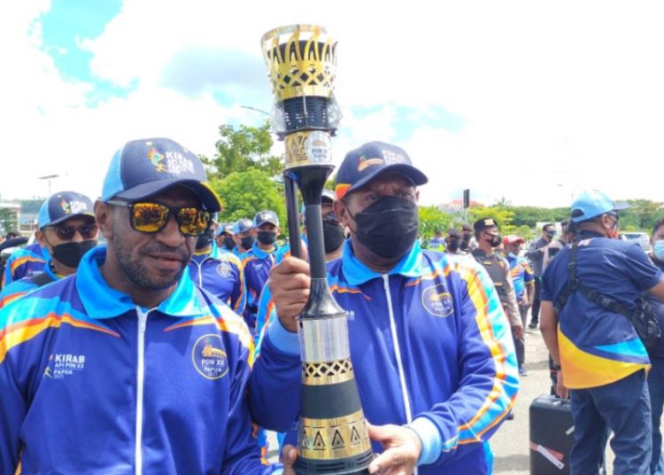 Mantan atlet Papua, Ronny Wabia dan Ortizan Solossa memegang obor Api PON XX usai upacara pelepasan di Halaman Kantor Bupati Sorong pukul 07.30 WIT.Obor Api PON selanjutnya diarak mengelilingi Lima wilayah adat hingga finish di Stadion Utama Lukas Enembe. (fornews.co/Foto: Humas PB PON)

 