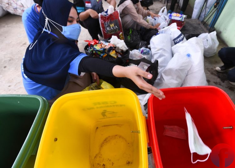 Relawan memisahkan sampah medis sesuai dengan kategori di Taman Edukasi Pertamina Talang Putri, Kecamatan Paju, Palembang, Sabtu (18/9/2021). (fornews.co/mushaful imam)