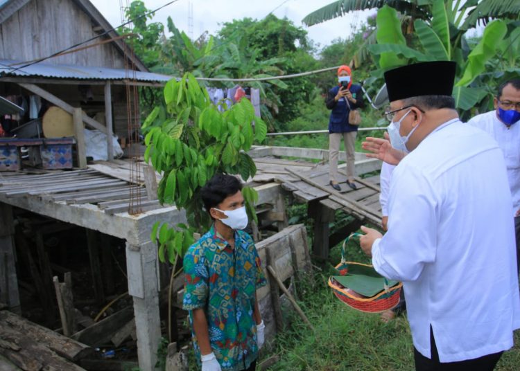 Bupati Muba, Dodi Reza saat menyerahkan daging kurban kepada salah seorang warga. (fornews / ist)