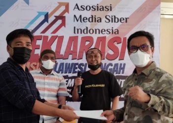 Koordinator AMSI Wilayah Indonesia Timur, Upi Asmaradhana, menyerahkan berita acara kepada Ketua terpilih Moh Iqbal Rasyid sebagai Ketua AMSI Wilayah Sulteng, di Hotel Amazing, Palu, Minggu (31/10/2021). (fornews.co/ist)
