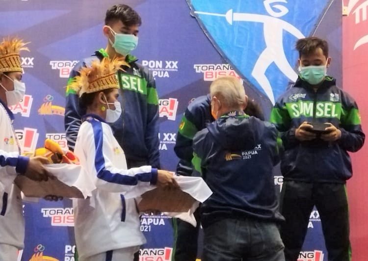 Tim Sabel Beregu Putra Sumsel, Ricky Dhisullimah, M Irfandi Nurkamil dan M Diko Arfandi, saat pengalungan medali emas yang langsung disematkan oleh sang pelatih dan manajer Lukman Ahmady, Kamis (7/10/2021). (fornews.co/ist)