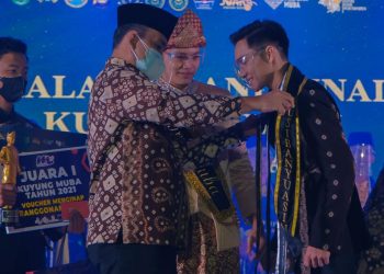 Plt Bupati Muba, Beni Hernedi menyematkan selempang Kuyung Muba 2021 kepada Muhammad Apriza, setelah resmi terpilih pada malam Grand Final Kuyung Kupek Muba di Opproom Pemkab Muba, Kamis (28/10/2021). (fornews.co/humas pemkab muba)